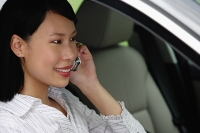 Businesswoman sitting in car using mobile phone - Asia Images Group
