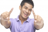 Man smiling, making hand sign - Asia Images Group