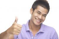Man smiling at camera, making thumbs up sign - Asia Images Group