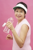 Mature woman wearing sun visor and water bottle - Asia Images Group