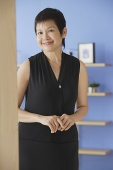Mature woman in black dress, smiling at camera - Asia Images Group