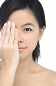 Young woman covering half her face with her hand - Asia Images Group