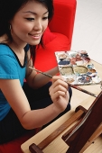 Woman painting, holding palette - Asia Images Group