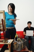 Couple at home, woman painting on easel, man using laptop - Asia Images Group
