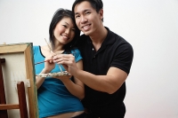 Couple at home, standing in front of easel with palette and paint brushes - Asia Images Group