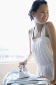 Woman ironing, smiling at camera - Asia Images Group
