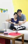 Couple in living room, looking at camera - Asia Images Group
