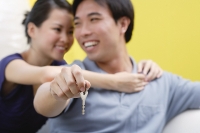 Woman embracing man from behind, man holding keys - Asia Images Group