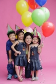 Mother and three children, posing with balloons - Asia Images Group