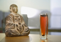 Still life with glass of tea and Buddha icon - Asia Images Group