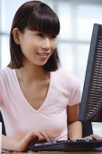 Young woman sitting in front of computer - Asia Images Group