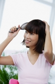 Young woman brushing her hair - Asia Images Group