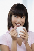 Young woman holding mug, smiling - Asia Images Group