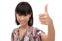 Young woman smiling at camera, making thumbs-up sign - Asia Images Group