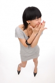 Young woman looking away, hands over mouth - Asia Images Group