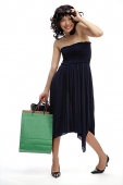 Woman in black dress, carrying shopping bags - Asia Images Group