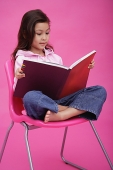 Girl sitting on chair, reading book - Asia Images Group