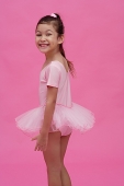 Young girl in ballet outfit, turning to smile at camera - Asia Images Group