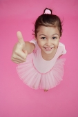 Young girl in ballet outfit, giving thumbs up sign - Asia Images Group