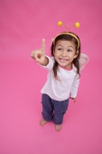 Young girl wearing fairy wings and deely bopper, making a hang sign - Asia Images Group