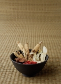 Bowl filled with Chinese medicinal herbs, still life - Asia Images Group