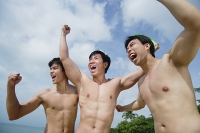 Three shirtless men raising fists - Asia Images Group