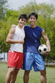 Two men looking at camera, one holding soccer ball - Asia Images Group