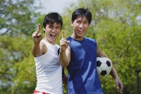 Two men looking at camera, making hand sign - Asia Images Group