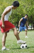 Two men playing soccer in park - Asia Images Group