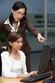Two businesswomen working together, looking at computer - Asia Images Group