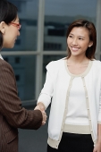 Two businesswomen shaking hands - Asia Images Group