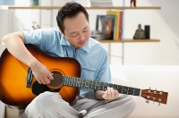 Man playing the guitar - Asia Images Group