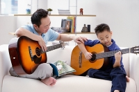 Father teaching son to play the guitar - Asia Images Group