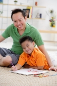 Father and son in living room, smiling at camera, portrait - Asia Images Group