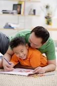 Father and son at home, drawing on sketch pad - Asia Images Group
