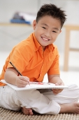 Boy with sketch pad, smiling at camera - Asia Images Group