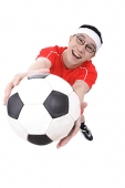 Man holding soccer ball towards camera - Asia Images Group
