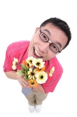 Man holding flower bouquet, smiling at camera - Asia Images Group