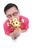 Man smelling flower bouquet - Asia Images Group