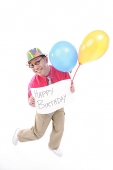 Man with party hat holding balloons and a sign - Asia Images Group