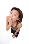 Young woman covering mouth, looking at camera - Asia Images Group