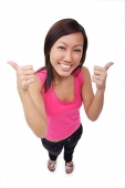 Young woman making thumbs up sign, smiling up at camera - Asia Images Group
