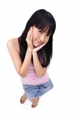 Young woman with hands on face, smiling at camera - Asia Images Group