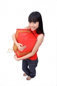 Young woman hugging big red gift box - Asia Images Group