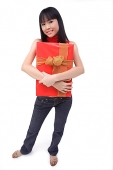 Young woman embracing big red gift box - Asia Images Group