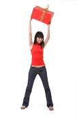Young woman holding big red gift box over her head - Asia Images Group