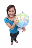 Woman holding globe, smiling at camera - Asia Images Group