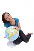 Woman sitting on floor with globe - Asia Images Group