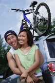 Couple standing next to SUV, portrait - Asia Images Group
