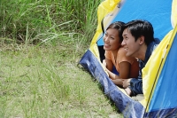 Couple lying in tent, looking out - Asia Images Group